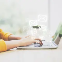 Frau tippt auf Laptop, E-Mail-Symbole schweben darüber. Ein **brief vertraulich** wird gesendet.