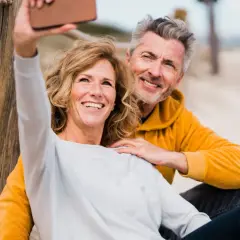 Glückliches Paar am Strand macht ein Selfie. So einfach wie das, wie stelle ich Bilder in den Status.