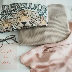 Ein T-Shirt mit Leopardenprint und der Aufschrift "REBELLION", ein Strickpullover und ein Seidenkleid – ein Blick auf die Geschichte der Mode.