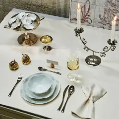 Ein festlich gedeckter Tisch mit Austern, Kerzenleuchter, Weinglas und Besteck. Der **Brotteller** ist bereits eingedeckt, bereit für ein elegantes Mahl.