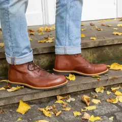 Herren-Outfit: Braune Schuhe kombinieren mit lässiger Jeans und Herbstlaub.
