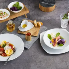 Zwei exquisite Gerichte: Links ein Teller mit Tortellini und Meeresfrüchten, rechts ein Teller mit Entenbrust und violettem Püree. Welchen salatteller möchtest du?