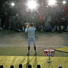 Tennisspieler mit Pokal im Blitzlichtgewitter der Fotografen. Ein Moment des Triumphs im gentleman sport.