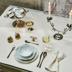 Festlich gedeckter Tisch im Restaurant mit Austern, Kerzen und goldenen Dekorationen.