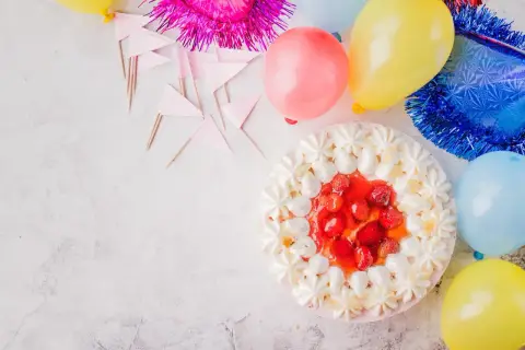 Einladung Sommerfest Firma: Bunte Ballons, Girlanden und eine köstliche Erdbeertorte laden zum Feiern ein.