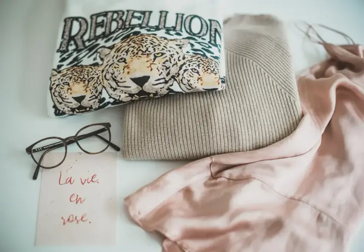 Ein T-Shirt mit Leopardenprint und der Aufschrift "REBELLION", ein Strickpullover und ein Seidenkleid – ein Blick auf die Geschichte der Mode.