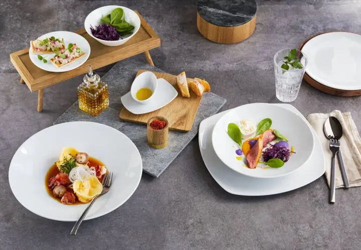 Zwei exquisite Gerichte: Links ein Teller mit Tortellini und Meeresfrüchten, rechts ein Teller mit Entenbrust und violettem Püree. Welchen salatteller möchtest du?