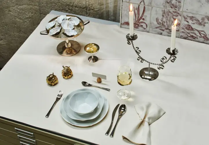 Festlich gedeckter Tisch im Restaurant mit Austern, Kerzen und goldenen Dekorationen.