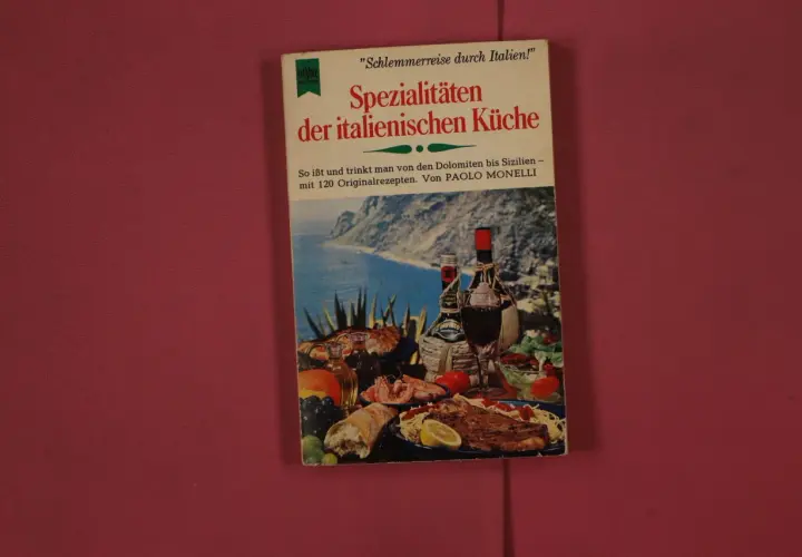 Buchcover "Spezialitäten der italienischen Küche" mit einem Bild von italienischem Essen und Wein, das die Tischsitten in Italien thematisiert.