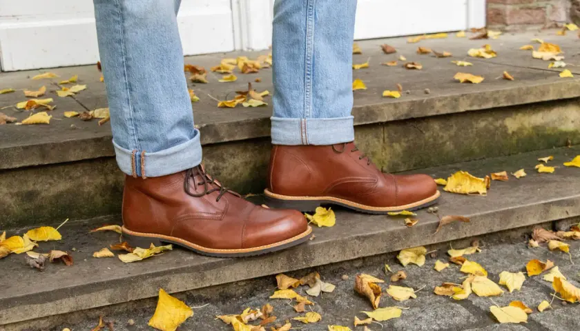Herren-Outfit: Braune Schuhe kombinieren mit lässiger Jeans und Herbstlaub.