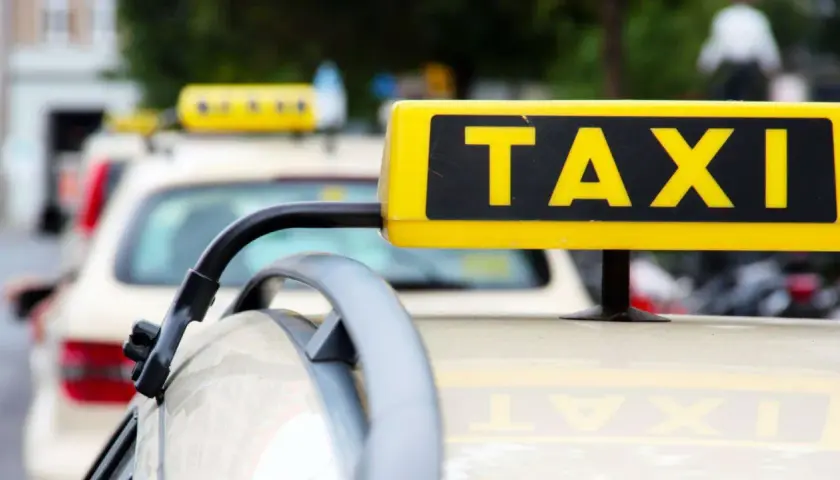 Gelbes TAXI-Schild auf einem Auto. Ein Blick auf den Taxi-Knigge für eine angenehme Fahrt.