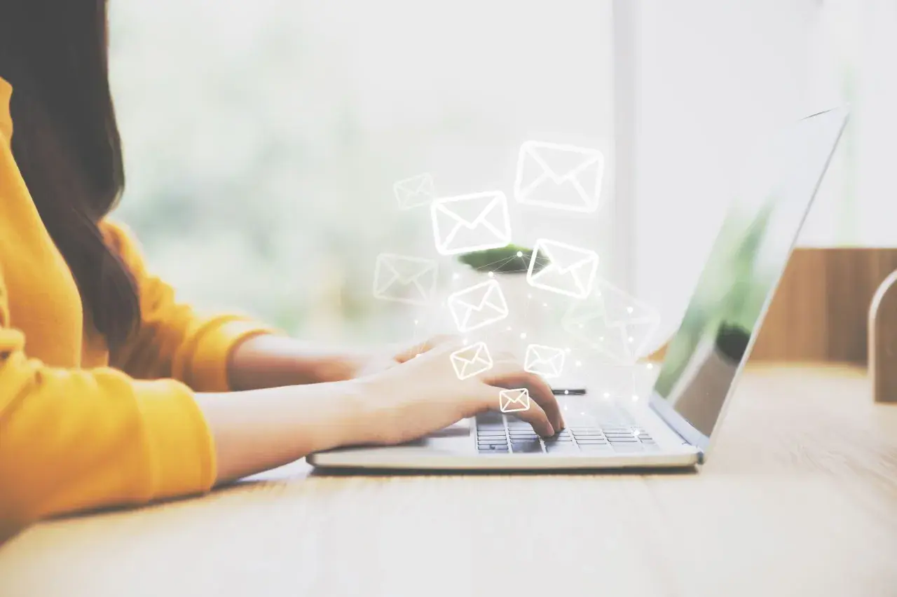 Frau tippt auf Laptop, E-Mail-Symbole schweben darüber. Ein **brief vertraulich** wird gesendet.