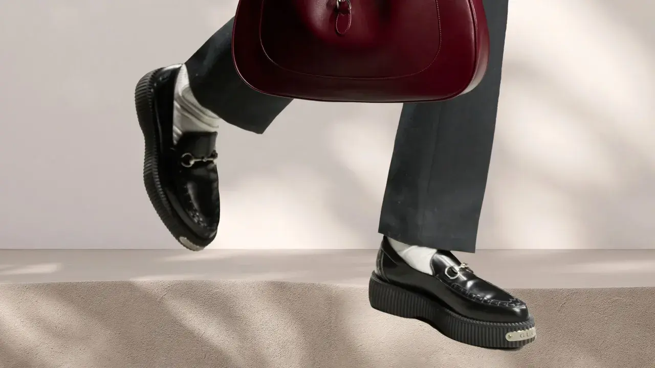 Schwarze Loafer mit Gucci-Detail und einer roten Handtasche. Perfekt für die Aufbereitung von Lederschuhen.