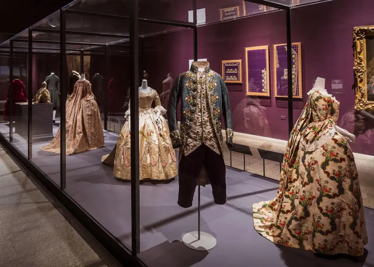 Prunkvolle Kleider und ein bestickter Herrenrock erz&auml;hlen die Geschichte der Mode in einer Museumsausstellung.