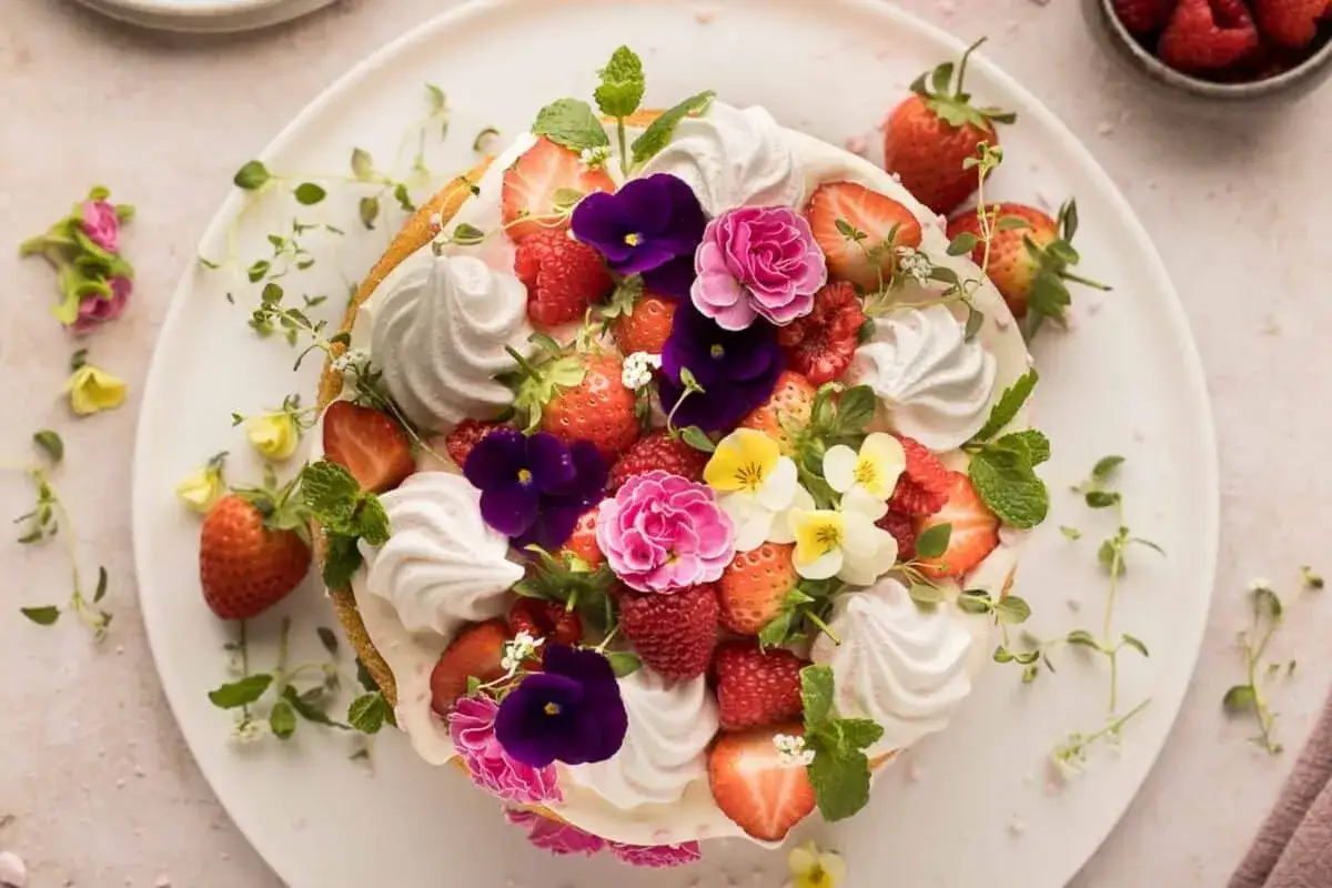 Kuchen mit frischen Erdbeeren, Himbeeren, Baiser und essbaren Blüten – tolle Dessert Deko Ideen für jeden Anlass.