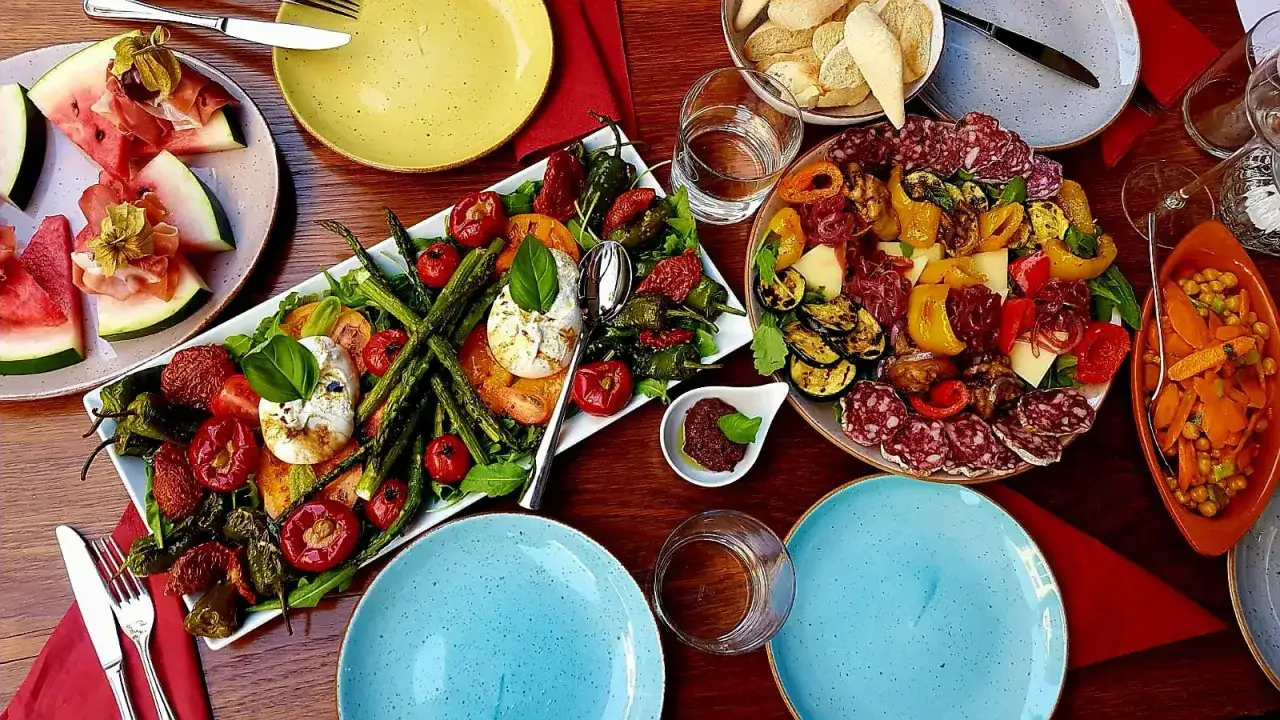 Ein Festmahl mit Antipasti, Burrata und Wassermelone – typische Tischsitten in Italien.