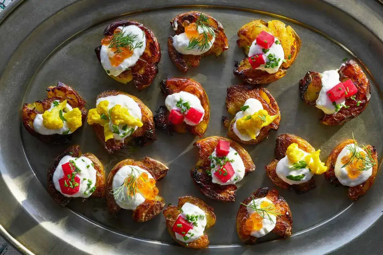 Knusprige Kartoffel-H&auml;ppchen mit cremigem Topping, Lachsrogen, roten W&uuml;rfeln oder gelbem Blumenkohl &ndash; ein lustiges Fingerfood-Arrangement!