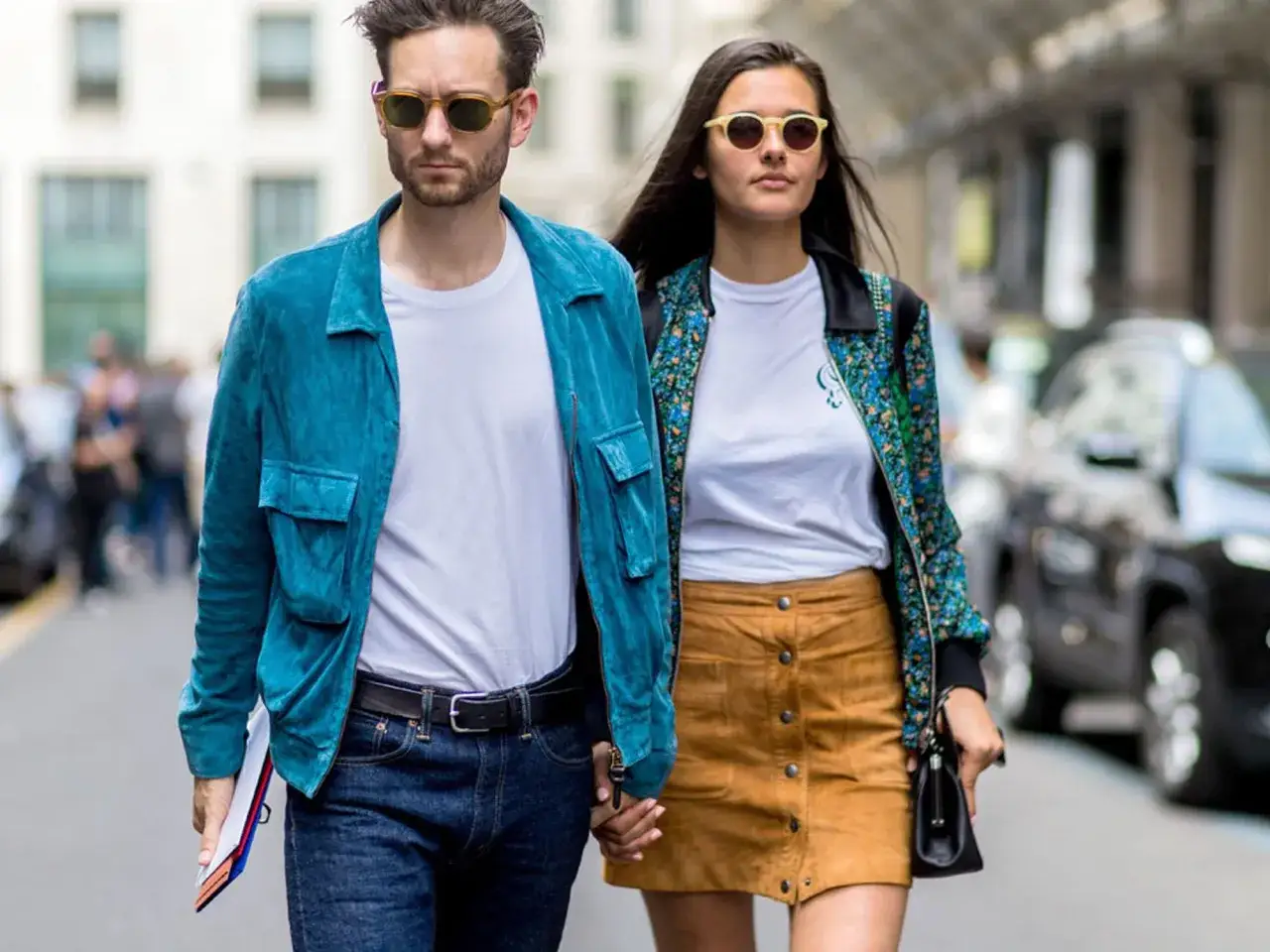 Ein Paar mit stylischem Outfit für ein erstes Date: Er trägt eine blaue Wildlederjacke, sie einen braunen Wildlederrock.