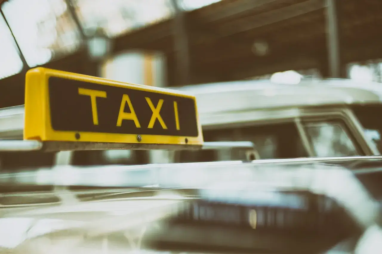 Gelbes TAXI-Schild auf einem Auto. Ein Blick auf den Taxi-Knigge f&uuml;r eine angenehme Fahrt.